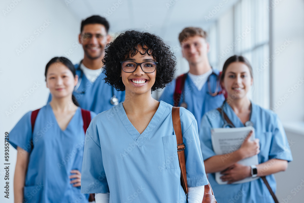 Portrait of a young nursing student standing with her team in hospital, dressed in scrubs Portrait of a young nursing student standing with her team in hospital, dressed in scrubs