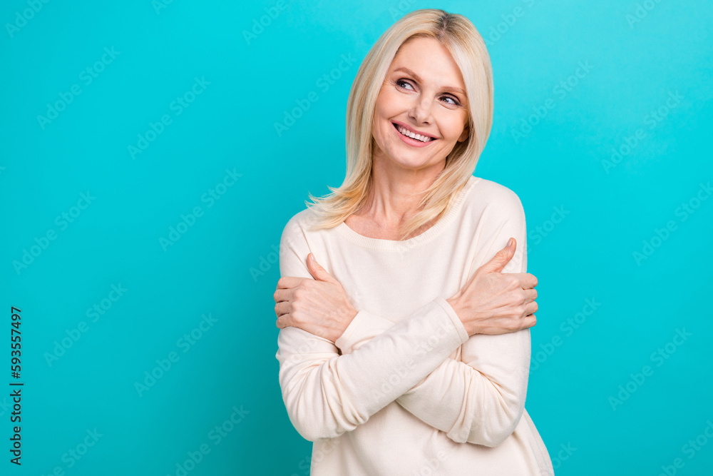 Photo of adorable dreamy woman wear white shirt hugging herself looking empty space isolated turquoise color background Photo of adorable dreamy woman wear white shirt hugging herself looking empty space isolated turquoise color background