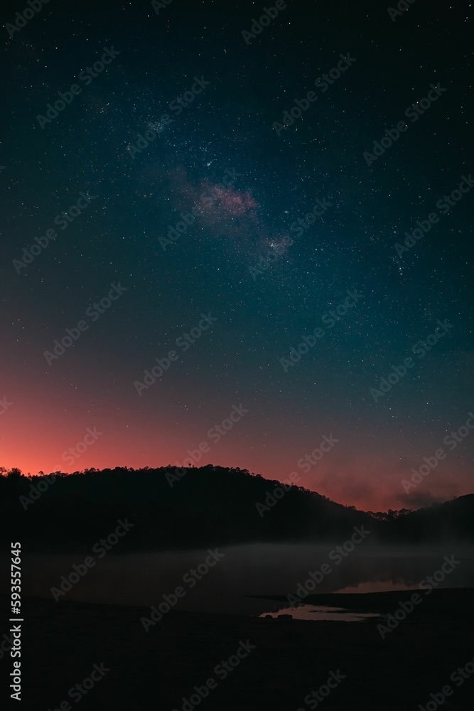 Calaque lake with silhouette view of mountains under vista sky full with stars in Jalisco, Mexico