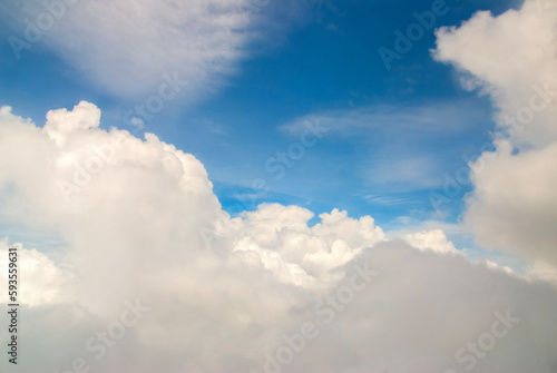 Fluffy clouds. Beautiful dramatic sunset sky above fluffy clouds in early morning from aerial drone view. Traveling by air. View from an airplane window. Aerial view of Malaysia.White clouds floating 