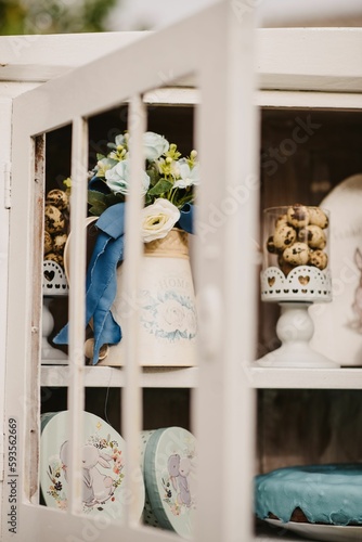 Vertical shot of flowers, cookies and cakes in the shelf for Easter decoration
