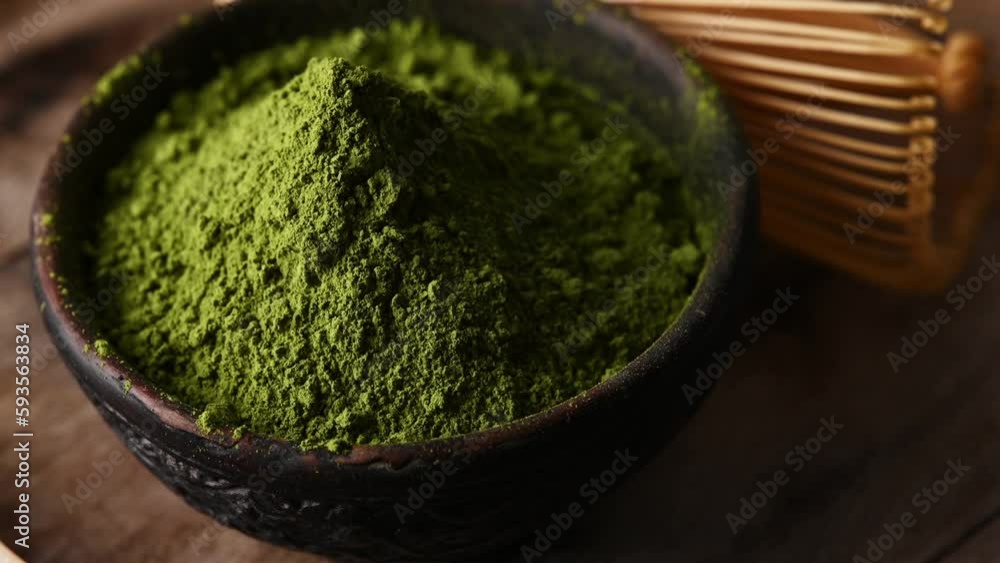 Matcha green tea powder in a bowl with a whisk for whipping Matcha green tea powder in a bowl with a whisk for whipping