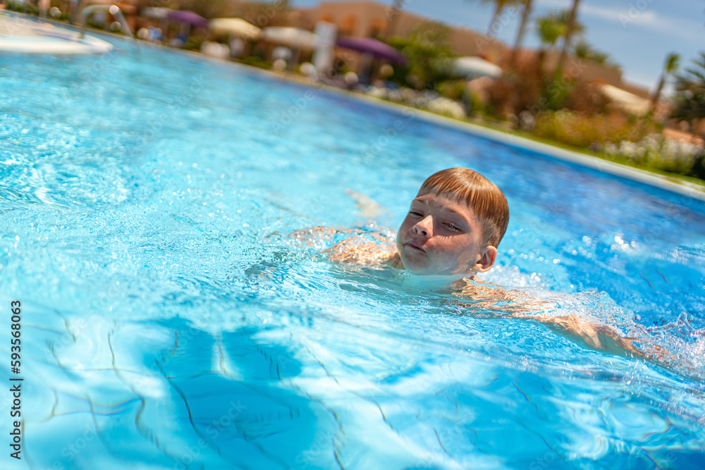 a boy is swimming in the pool. rest at the hotel