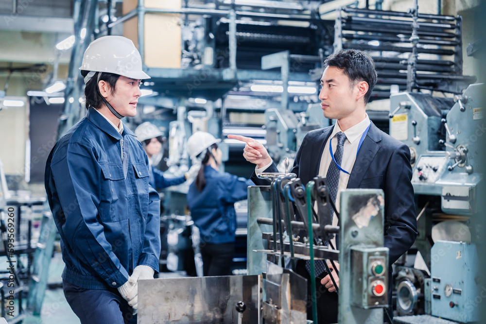 工場の作業員に注意をする経営者 工場の作業員に注意をする経営者