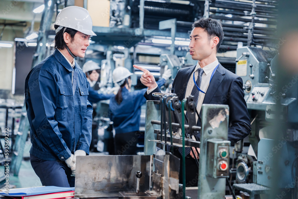 工場の作業員に注意をする経営者 工場の作業員に注意をする経営者