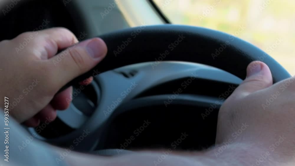 Hands holding the steering wheel of a car while driving Hands holding the steering wheel of a car while driving