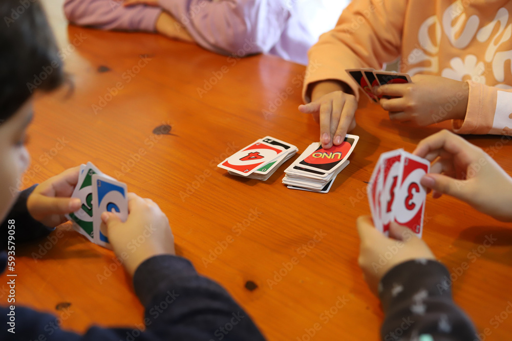 Group of children playing cards. Boys playing card game UNO. Board game. Teenagers having fun