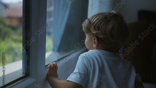 One little boy looking out window at home. Child staring out from the inside through glass Free Download One little boy looking out window at home. Child staring out from the inside through glass - GFXLoad