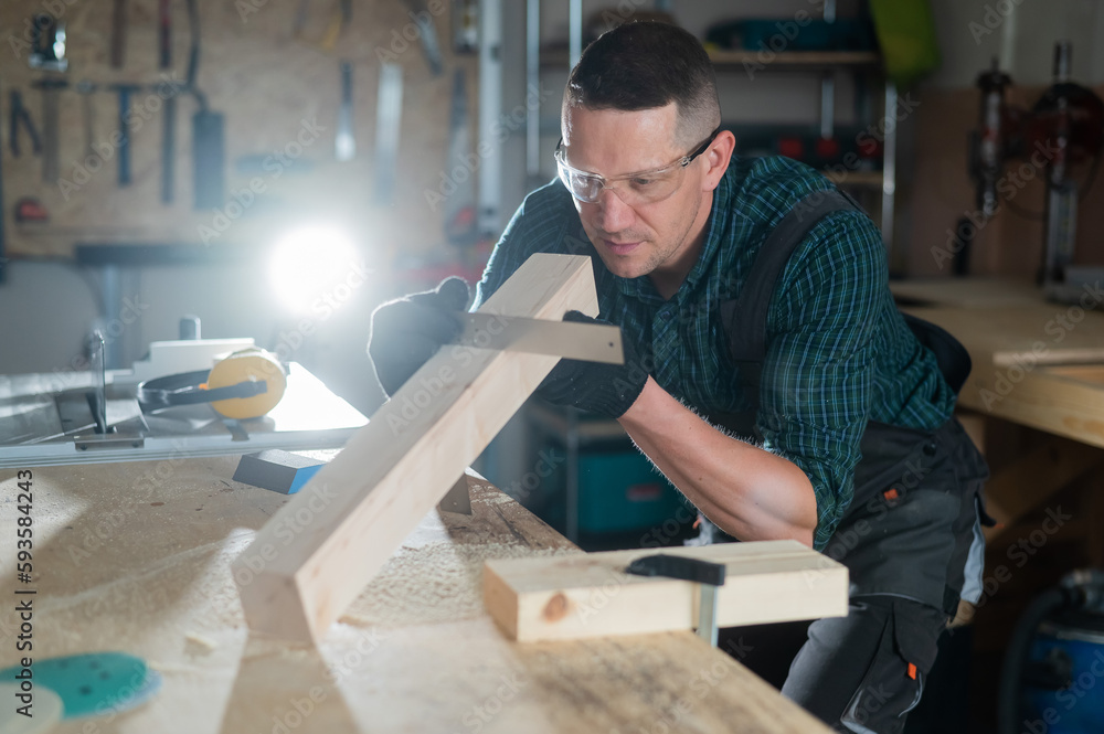 Carpenter measures a wooden board while working in a workshop. 