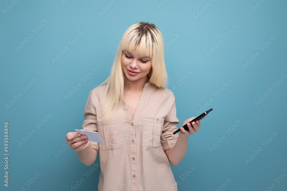 blondie young woman in casual clothes pays for purchase using smartphone and money card data blondie young woman in casual clothes pays for purchase using smartphone and money card data