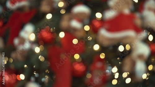 Huge Christmas tree decorated with red bows and balls, plush toys, shining lights. Impressive traditional holiday decorations with red boxes and gifts in a trade center. Winter feast in a toy store. 