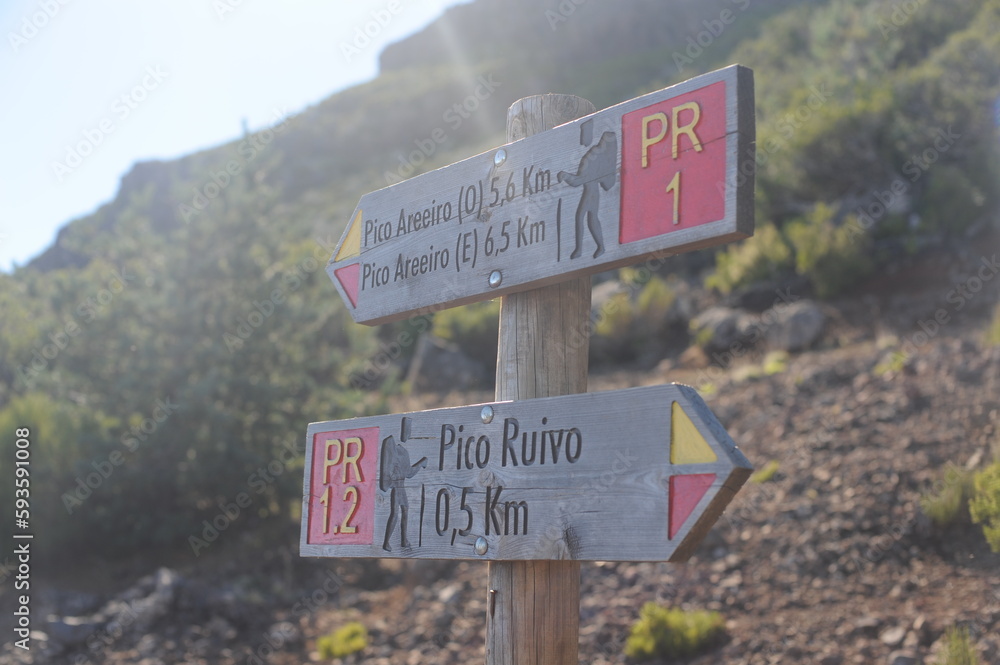 Signpost on the hiking trail or path showing the direction and distance in Madeira Island, Portugal, Europe Signpost on the hiking trail or path showing the direction and distance in Madeira Island, Portugal, Europe