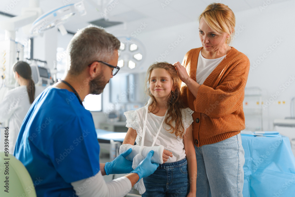 Obraz premium Mature doctor giving gypsum to little girl.