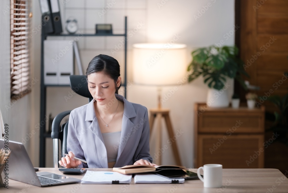 Creative Asian young woman working on laptop in her office. Creative Asian young woman working on laptop in her office.