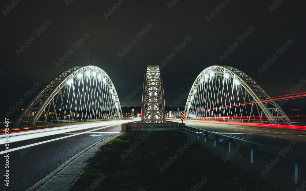 Obraz premium Strandherd-Armstrong Bridge, Now Called Vimy Memorial Bridge in Ottawa, Ontario, Canada, constructed 2014. Night photo with traffic light trails from long exposure. Modern trestle suspension design.