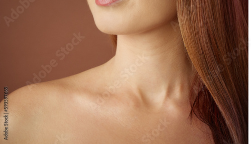 young women's neck shoulder and collarbone on brown nude background