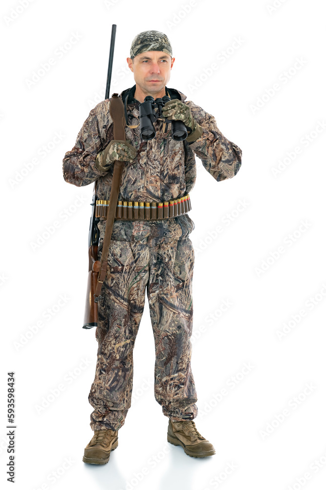 Full length portrait of a mature hunter with a shotgun, isolated on white background. Duck hunter with a rifle on his shoulder and binoculars looks to the side posing in studio. Full length portrait of a mature hunter with a shotgun, isolated on white background. Duck hunter with a rifle on his shoulder and binoculars looks to the side posing in studio.