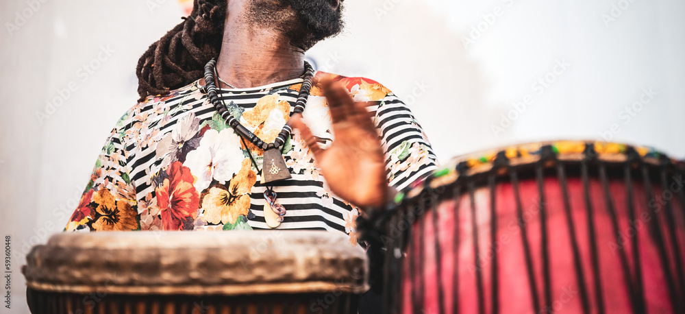 Uczestnik warsztatów muzycznych oddaje się rytom djembe. Ręce w ruchu, tworząc rytm, który wypełnia pomieszczenie. - obrazy, fototapety, plakaty 
