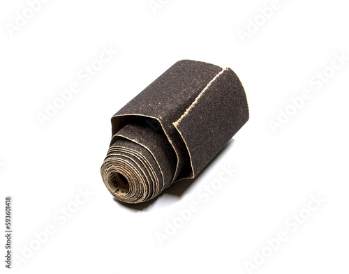 Dark sandpaper rolled up, on a white background.