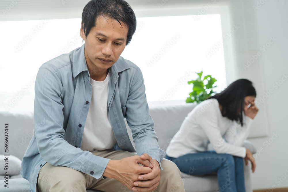 Family divorce problem concept, Husband and wife sitting separating after arguing in the living room at home. Family divorce problem concept, Husband and wife sitting separating after arguing in the living room at home.