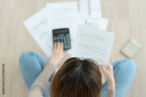 Stressed and headache woman with large bills or invoices no money to pay to expenses and credit card debt. shortage, Financial problem, bankruptcy, mortgage, loan, bankrupt, poor, empty wallet .