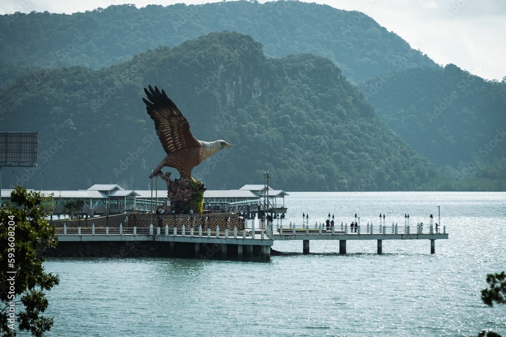 Fototapeta premium Big Eagle statue perched over a scenic waterfront plaza in Langkawi, Malaysia.