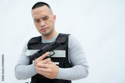 Portrait of police hold gun in hand on white background,Handsome asian cop