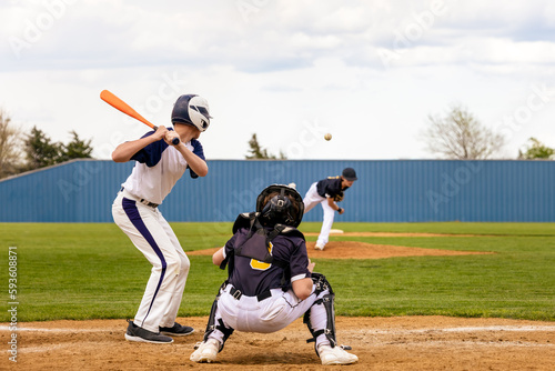 Baseball Player - Batter watching the pitched ball. Pitcher on the mound. Catcher ready at the plate. © kpeggphoto