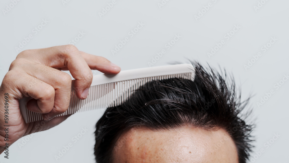 Naklejka premium Young confident asian chinese young man checking hair style and dandruff.