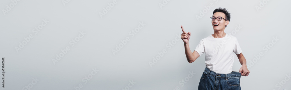 Young confident asian chinese weight loss man with oversize of jean pants. Young confident asian chinese weight loss man with oversize of jean pants.