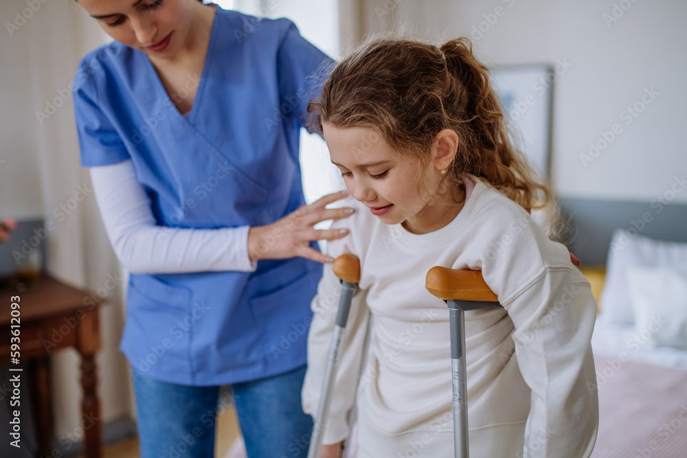 Εκτύπωση καμβά Young nurse helping to walk to little girl with broken leg.