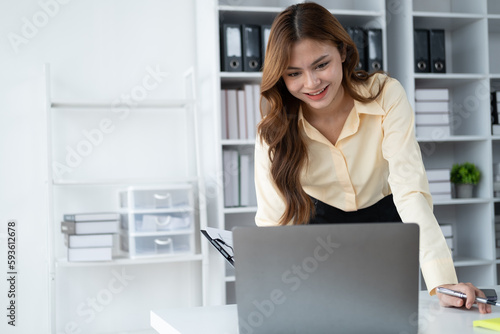 Beautiful buisnesswoman working and typing on laptop computer while sitting at her office desk.