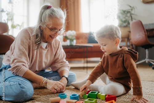 Photography Grandmother playing with her little grandson,building a block set