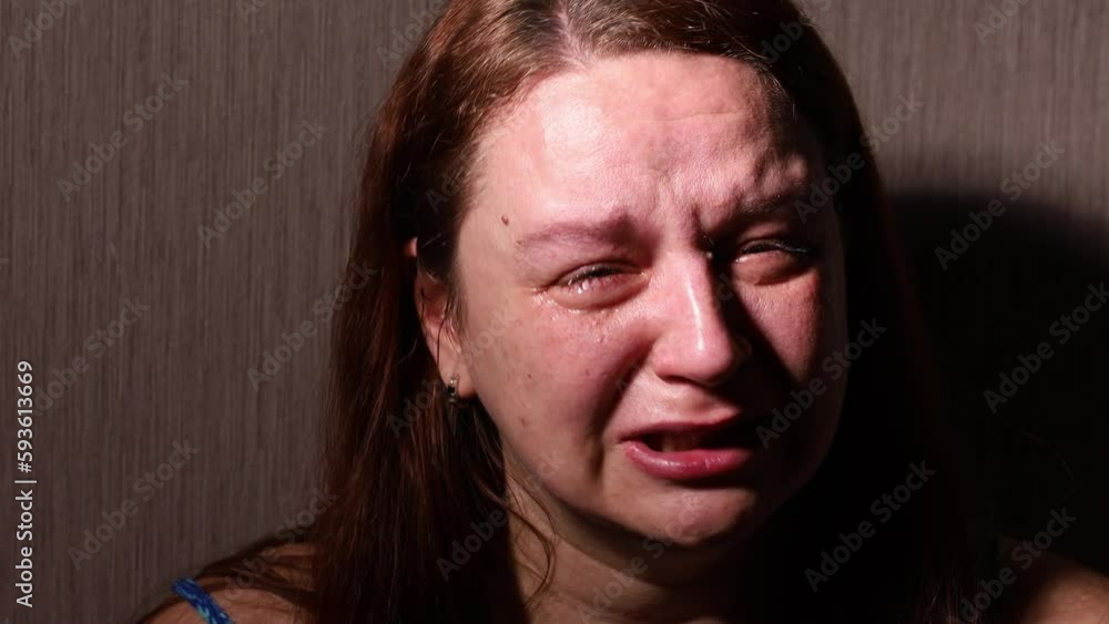 Distressed woman hysterically cry and speak out in dark room closeup
