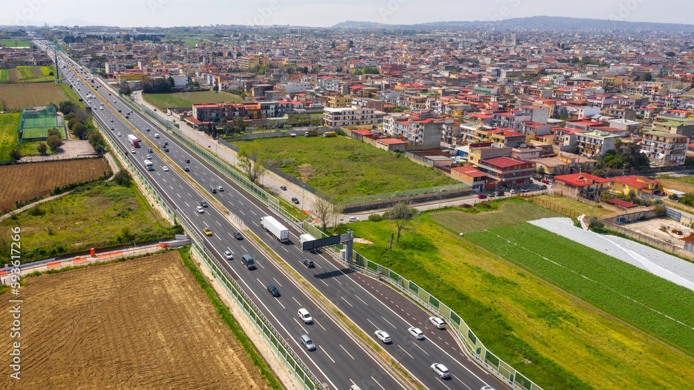 Aerial view of a section of the Italian motorway. On the right the town of Afragola, near Naples and Caserta, Italy.