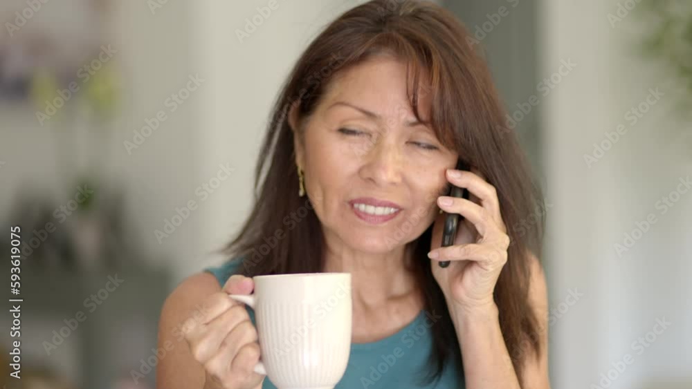 Close up cheerful woman smiling enjoying talking on mobile cell phone while drinking coffee Close up cheerful woman smiling enjoying talking on mobile cell phone while drinking coffee