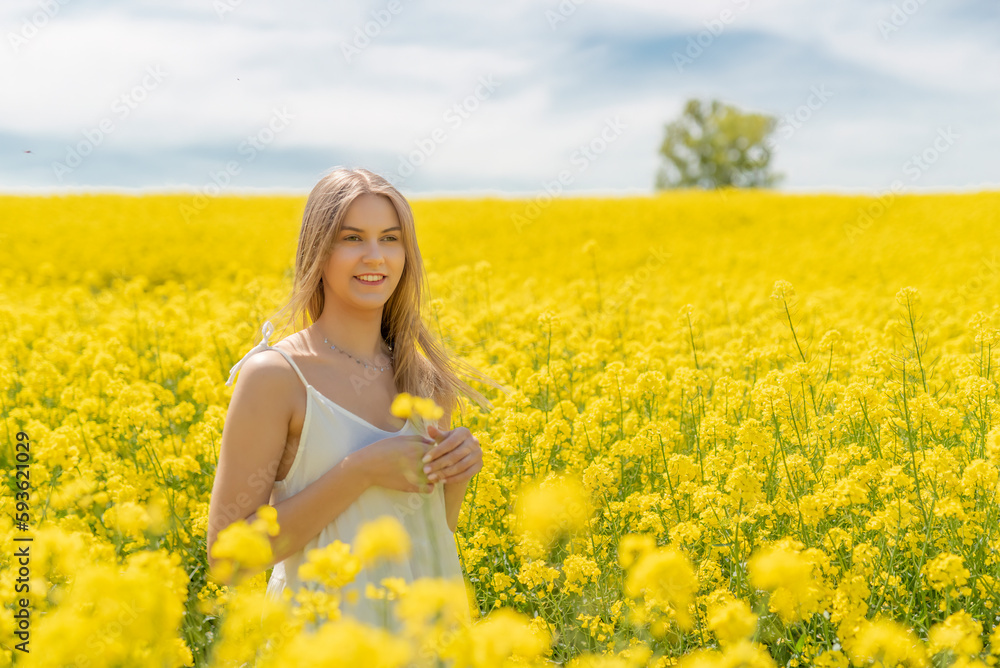 Beautiful woman with long blonde hair. He walks in the rapeseed field Beautiful woman with long blonde hair. He walks in the rapeseed field