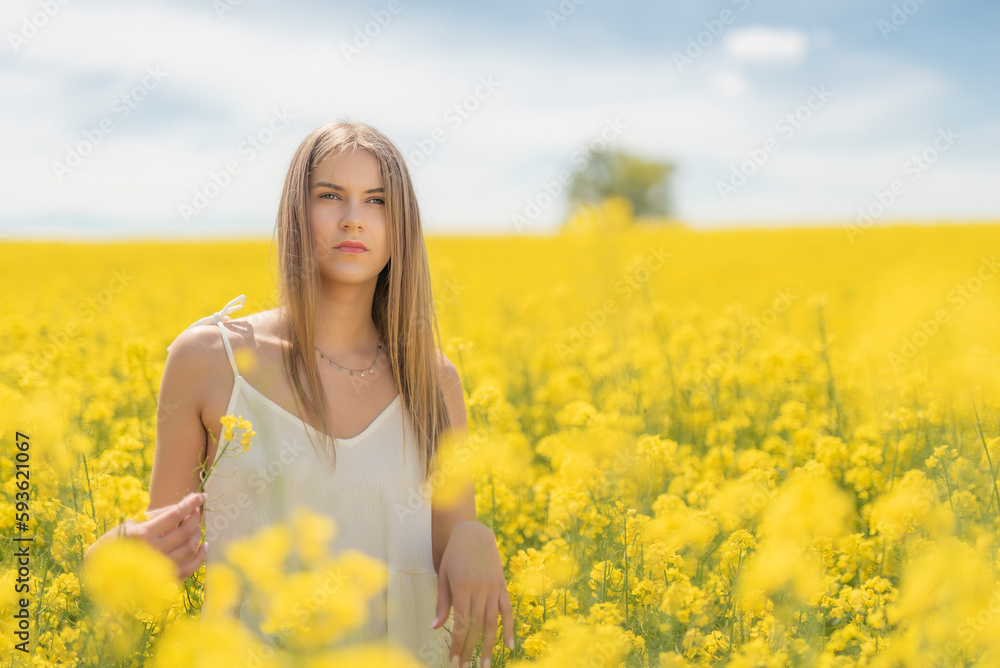 Beautiful woman with long blonde hair. He walks in the rapeseed field Beautiful woman with long blonde hair. He walks in the rapeseed field
