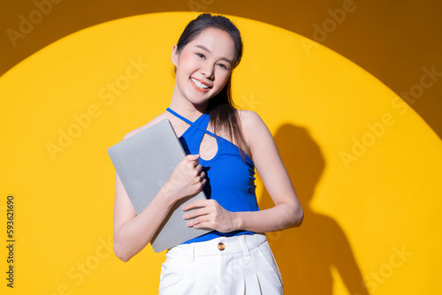 confident attractive stylish asian woman luxury dress cloth glamour smiling cheerful enjoy positive emotion hand hold laptop business look ae marketing confident facial expression studio shot photo