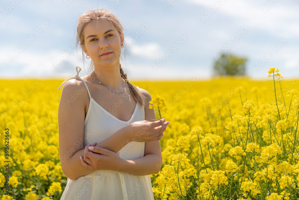 Beautiful woman with long blonde hair. He walks in the rapeseed field Beautiful woman with long blonde hair. He walks in the rapeseed field