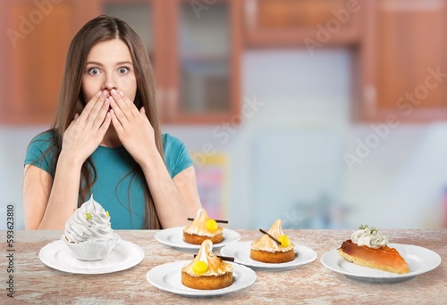 Funny young woman eating tasty sweet cake