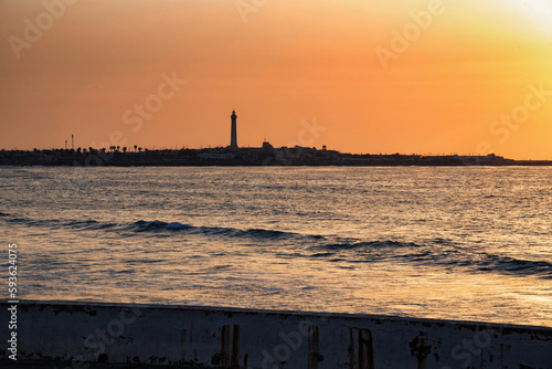Sunset over the Atlantic Ocean in Casablanca. Morocco. With lighthouse on the background.