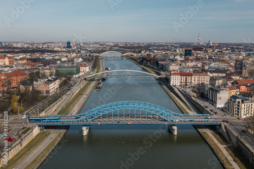 Cracow aerial view of city and Vistula river with blue Piłsudskiego bridge and Kładka Ojca Bernatka. On right Podgórze district, on left Kazimierz. Early spring 2023. photo