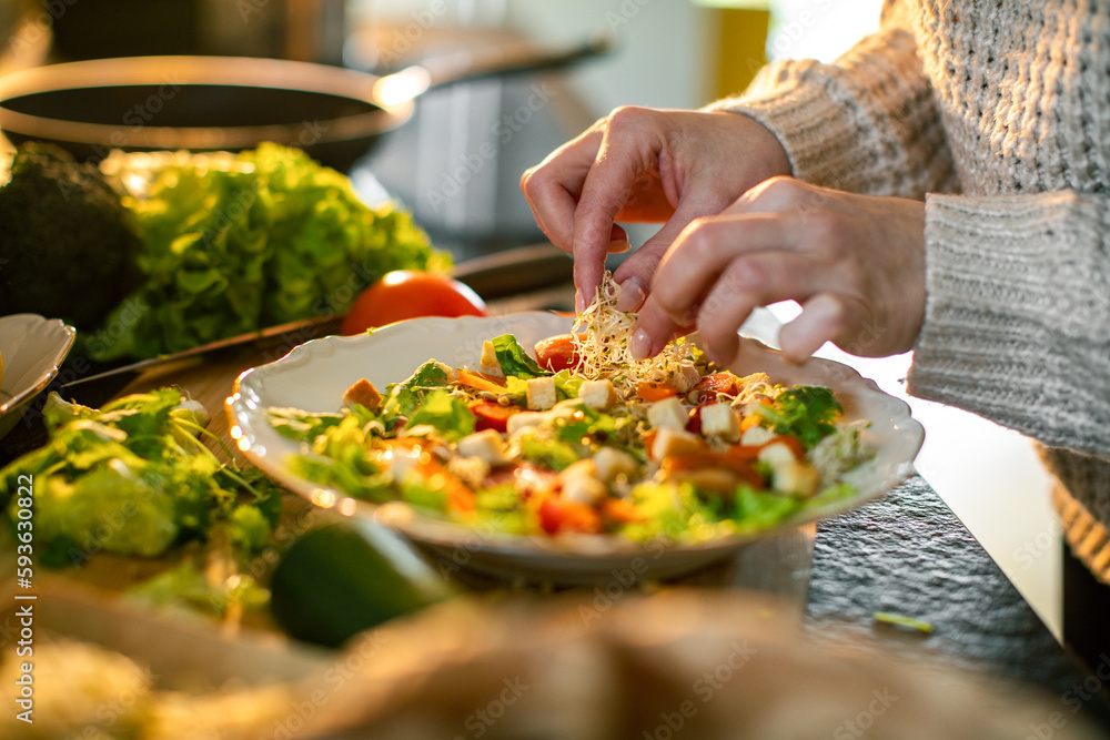 Young adult woman preparing a healthy salad in the kitchen Young adult woman preparing a healthy salad in the kitchen