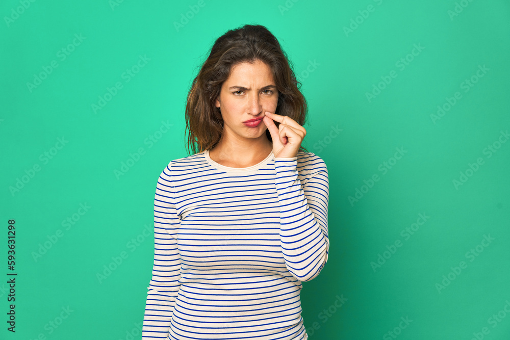 Young caucasian woman isolated with fingers on lips keeping a secret. Young caucasian woman isolated with fingers on lips keeping a secret.