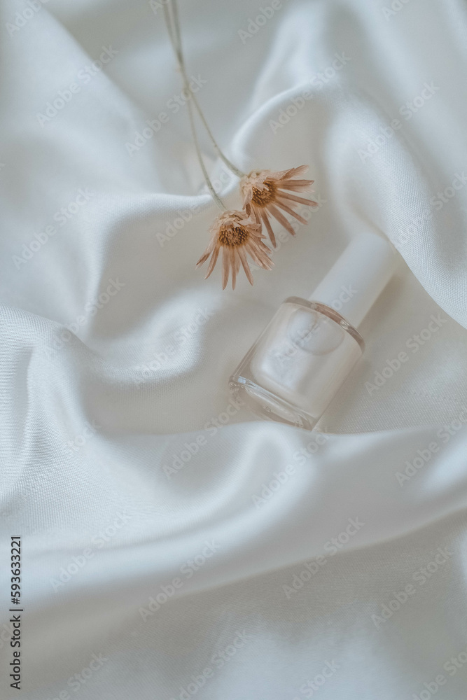 Obraz premium Nail polish bottles on white silk background, beauty and fashion concept