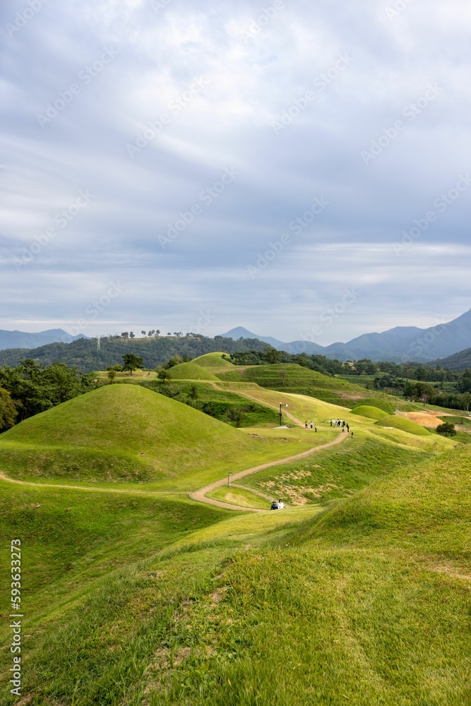Vertical shot of bright green hills with a path under a blue sky in Gyeongsangnam-do, South Korea Vertical shot of bright green hills with a path under a blue sky in Gyeongsangnam-do, South Korea