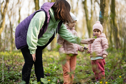 Mother with two daughters on forest. Outdoor spring leisure concept.