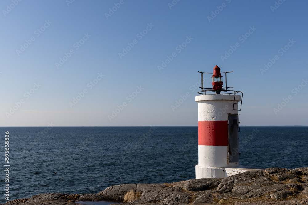 Lighthouse on rocks and view of the baltic sea horizon