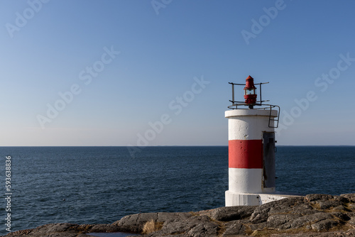 Fototapeta Naklejka Na Ścianę i Meble -  Lighthouse on rocks and view of the baltic sea horizon